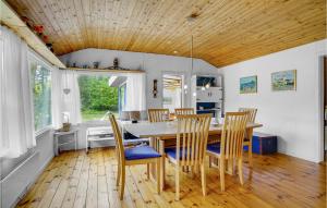 勒兹比港的住宿－Beautiful Home In Rdby With Kitchen，一间带木桌和椅子的用餐室