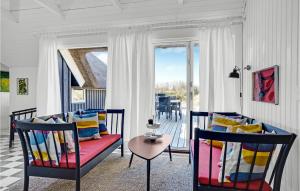 uma sala de estar com duas cadeiras e uma mesa em Cozy Home In Blvand With Kitchen em Blåvand