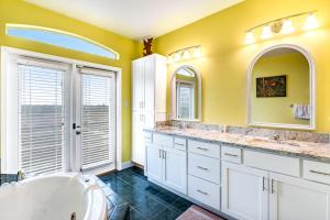 een badkamer met 2 wastafels, een bad en 2 spiegels bij Dolphin View by Meyer Vacation Rentals in Gulf Shores +23 foto's