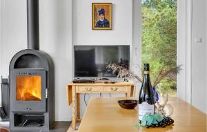 a living room with a fireplace and a bottle of wine at 3 Bedroom Stunning Home In Fan in Fanø