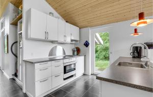 a kitchen with white cabinets and a sink at 3 Bedroom Lovely Home In Fanø in Fanø +17 photos