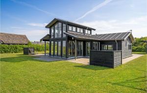 レムにある4 Bedroom Stunning Home In Skjernの緑の芝生の上に黒屋根の家