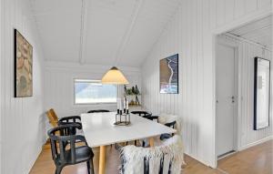 a dining room with a white table and chairs at Lærkereden in Vejers Strand