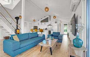 レムにあるAwesome Home In Skjern With 4 Bedrooms, Sauna And Wifiのリビングルーム(青いソファ、テーブル付)