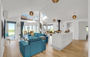 4 Bedroom Stunning Home In Skjern في Lem: غرفة معيشة مع أريكة زرقاء ودرج