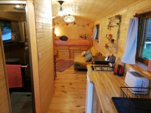 a kitchen and living room in a tiny house at Roulotte La Vert-Dîne in Saint-Pardoux