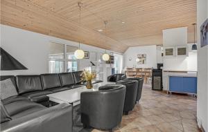 a living room with a table and leather chairs at Nice Home In Skjern With 6 Bedrooms, Sauna And Private Swimming Pool in Lem