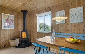a wood stove in a room with a table and chairs at Cozy Home In Frstrup With Kitchen in Lild Strand