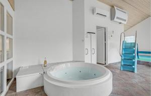 a large white bathroom with a tub and a blue chair at Stunning Home In Skjern With Kitchen in Lem