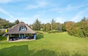 a thatch roofed house with a yard at Holiday Home Thyholm 12 in Thyholm +13 photos