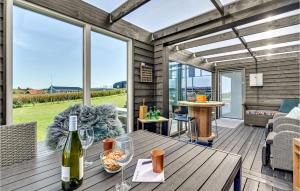 un patio con una mesa de madera y una botella de vino en Stunning Home In Lemvig With Wifi, en Lemvig