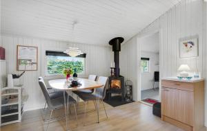 comedor con mesa y estufa de leña en Amazing Home In Herning With Kitchen, en Kølkær