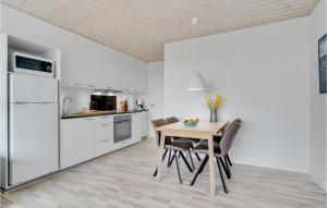 cocina y comedor con mesa de madera y sillas en Lovely Apartment In Rm With Wifi en Rømø Kirkeby