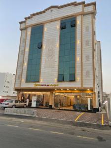 a building with a car parked in front of it at Afdal Rehla Serviced Apartments in Jazan