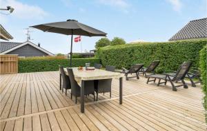 a patio with a table and chairs and an umbrella at 3 Bedroom Awesome Home In Hejls in Hejls