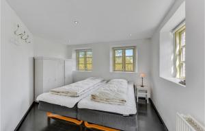 Fjand GårdeにあるAwesome Home In Ulfborg With 12 Bedrooms And Wifiの白いベッドルーム(ベッド2台、窓付)