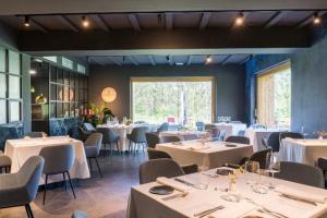 een eetkamer met witte tafels en stoelen bij Agroturismo Azkarraga in Amorebieta-Etxano