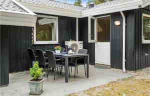 a patio with a table and chairs and a house at Holiday Home Småfolksvej Rømø Xii in Bolilmark