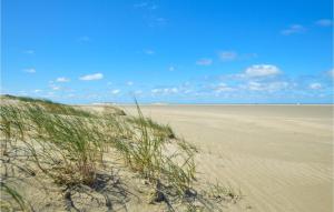 a sandy beach with grass in the middle of it at Holiday Home Småfolksvej Rømø Xii in Bolilmark +21 photos
