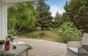a wooden deck with a view of a forest at Holiday Home Småfolksvej Rømø Xii in Bolilmark