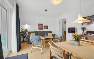 Amazing Apartment In Rudkbing With Kitchen في رودكوبينغ: غرفة معيشة مع طاولة وكراسي وأريكة