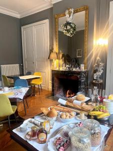 uma mesa com comida e lareira em La Grande Carrée em Saint-Cyr-sur-Loire