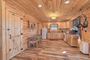 a kitchen with wooden walls and a wooden floor at Quiet and Secluded Berea Cabin on 70-Acre Farm! in Berea