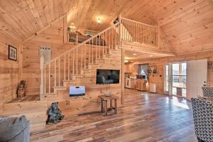 a living room with a staircase in a wooden house at Quiet and Secluded Berea Cabin on 70-Acre Farm! in Berea