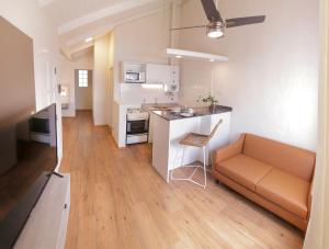 cocina y sala de estar con sofá y mesa en La Olla Complejo Turistico en Santa Rosa de Calamuchita