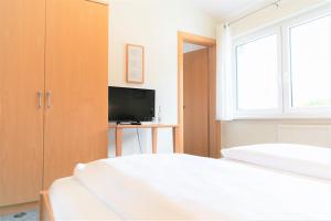sypialnia z 2 łóżkami i telewizorem w obiekcie Gästehaus TABOR w mieście Marburg