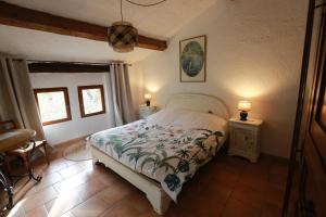 1 dormitorio con 1 cama, 2 mesas y 2 lámparas en Le Priolat des Anges aux portes des gorges du Verdon, en Trigance