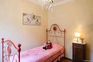 Un dormitorio con una cama rosa con un osito de peluche. en Villa Malula a classy house in the countryside, en Capannori
