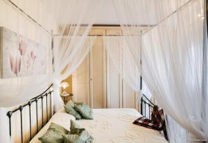 a bedroom with a bed with white drapes at Villa Malula a classy house in the countryside in Capannori