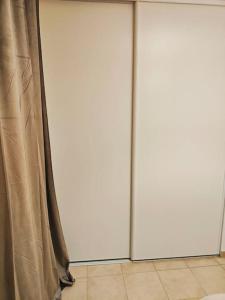 two sliding doors in a room with curtains at Appartement des Carmes in Nîmes