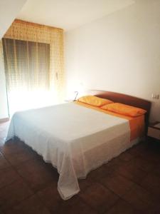 een slaapkamer met een groot wit bed en een raam bij La casa di Antonella in Vico del Gargano