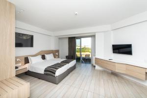 ein Hotelzimmer mit einem Bett und einem TV in der Unterkunft Evalena Beach Hotel in Protaras