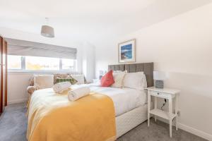 a white bedroom with a bed and a window at Radernie Place - 3 Bedroom House - Sleeps 6 in St. Andrews