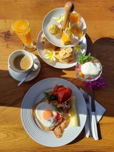 a table with three plates of breakfast foods and a cup of coffee at Agia Roumeli Hotel in Agia Roumeli