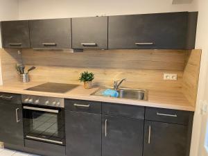 a kitchen with a sink and a stove at Ferienwohnung Welk in Grömitz