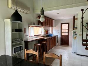 eine Küche mit Holzschränken und einer schwarzen Arbeitsplatte in der Unterkunft CASA MARÍTIMA EN PORTEZUELO, MALDONADO, URUGUAY in Punta del Este