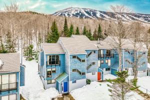 een blauw huis in de sneeuw met een berg op de achtergrond bij Sugarloaf Mountain Treasure in Carrabassett