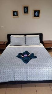 Una cama con un edredón azul con una camisa. en Playa Blanca - Moro Blue, en Cancún