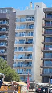 un edificio de apartamentos alto con un aparcamiento enfrente en Sol y mar, en Monte Hermoso