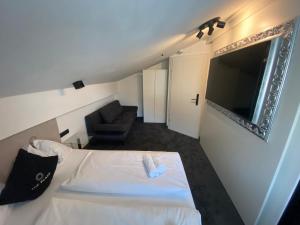 mały pokój z łóżkiem i kanapą w obiekcie The Place Boutique & Design Hotel Flachau w mieście Flachau
