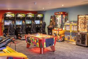 a room with many video games and a table in front of machines at Camping Pods Silver Sands Holiday Park in Lossiemouth