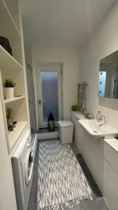 een badkamer met een wastafel, een spiegel en een tapijt bij the flat with the heart in Londen