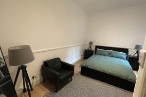een slaapkamer met een bed, een stoel en een lamp bij the flat with the heart in Londen