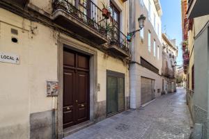 an empty alley with a brown door on a building at SANTA PAULA CENTRO JUNTO CATEDRAL center in Granada