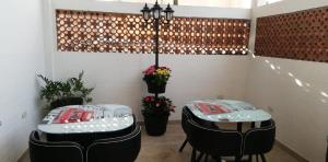 two tables in a room with chairs and flowers at Hotel Boutique el Sol in Cartago