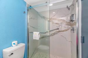 y baño con ducha de cristal y aseo. en Sun N Sand Resort en Myrtle Beach